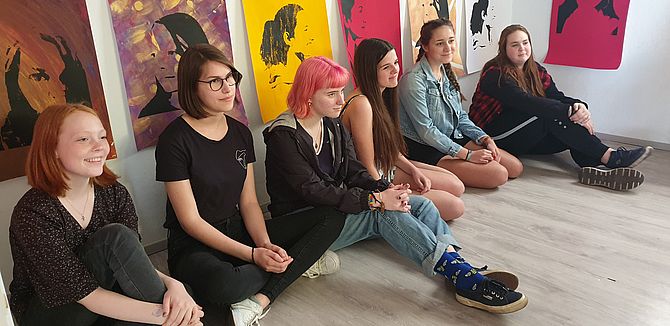 Teilnehmerinnen des Jugendkunstprojekts, am Boden sitzend