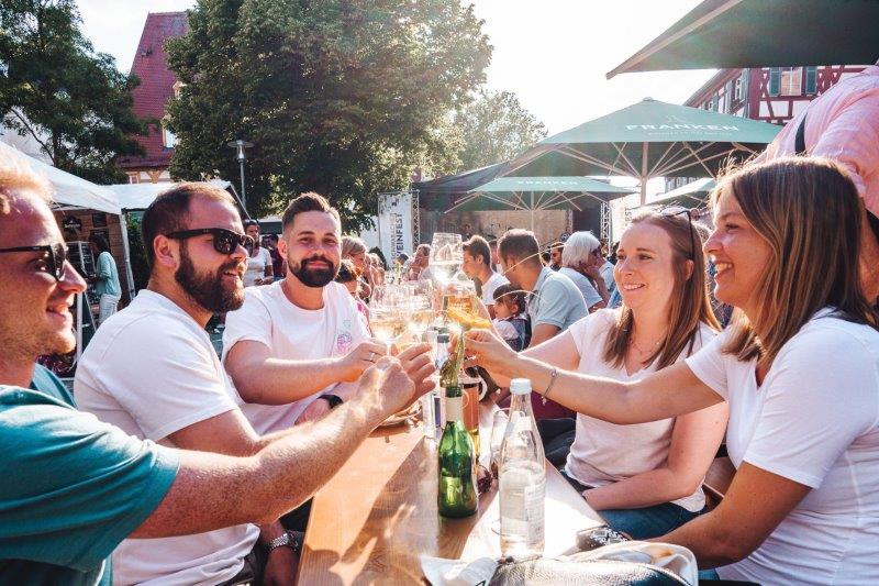 sich zuprostende Menschen auf dem Weinfest