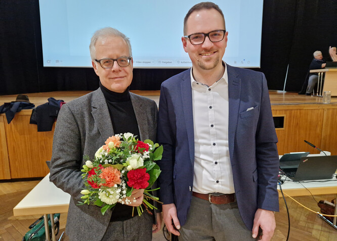 Knut Engelbrecht hat von Oberbürgermeister Peter Reiß einen Blumenstrauß
