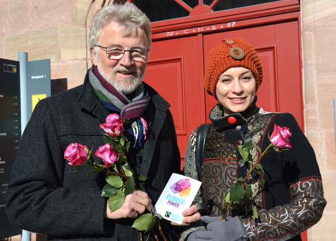 Dr. Roland Oeser übergibt eine Fairtrade-Rose an eine Schwabacherin.