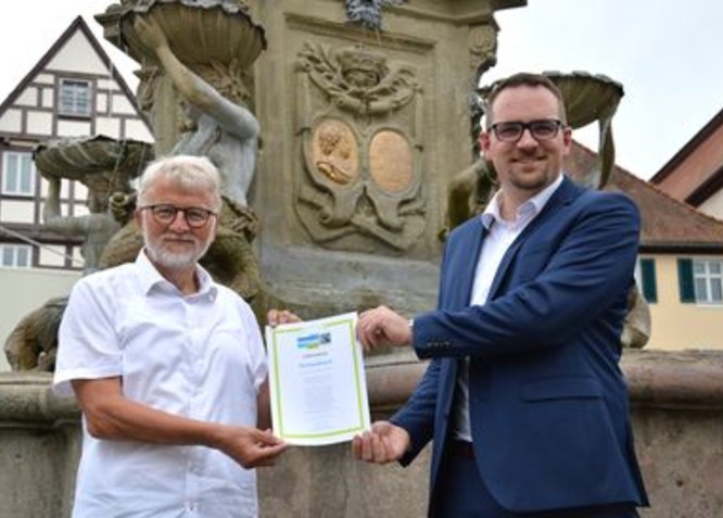 Oberbürgermeister Peter Reiß und Alt-Bürgermeister Roland Oeser freuen sich über die erneute Rezertifierung Schwabachs als Fairtrade-Town.
