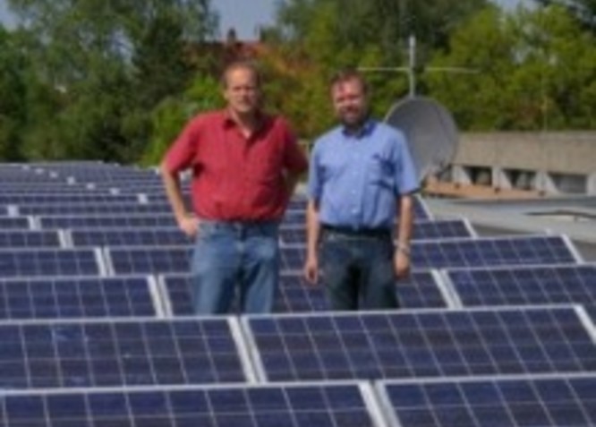 die Agenda 21-Aktiven Dr. Gerhard Brunner und Martin Sauer inmitten einer Solaranlage, die Aufgrund ihres ehrenamtlichen Engagements errichtet wurde. 
