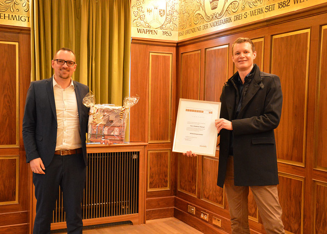 Peter Reiß überreicht dem neuen Altoberbürgermeister Matthias Thürauf die Ernennungsurkunde und ein Fotobuch mit Aufnahmen aus dessen Amtszeit.