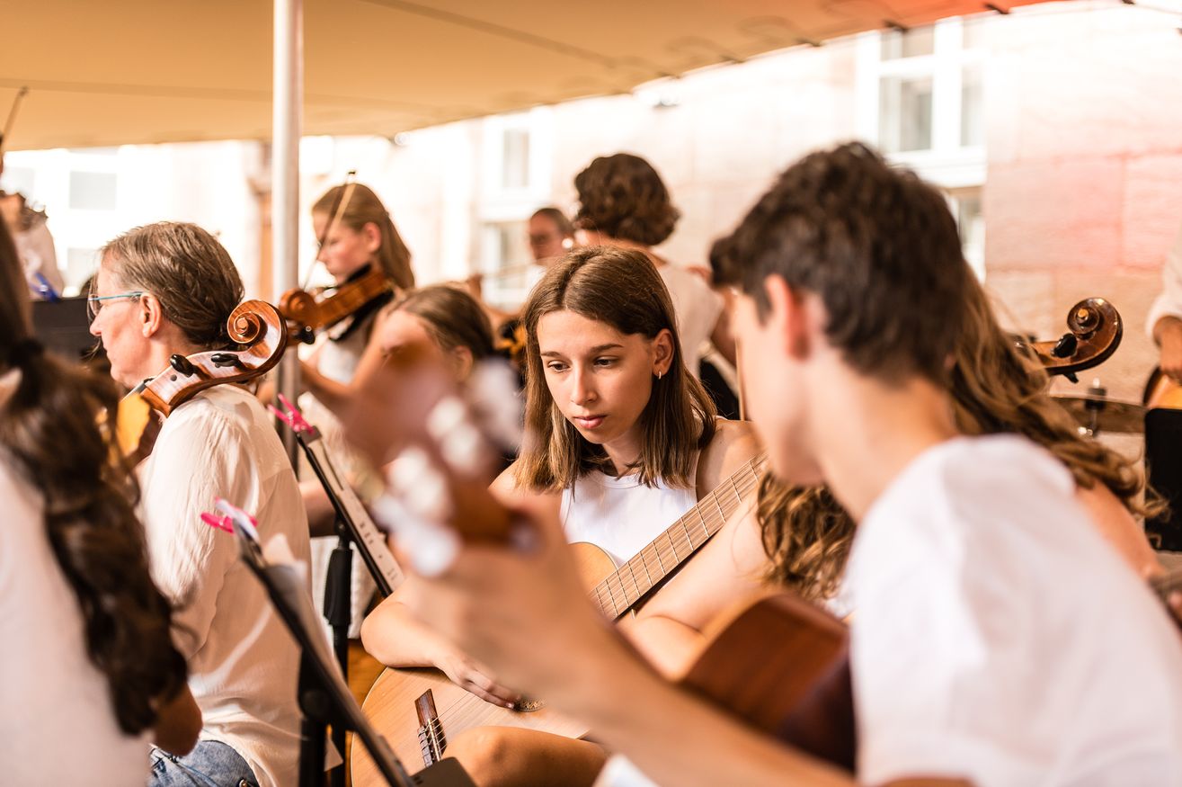 Schüler:innen spielen im Orchester beim Open Air-Konzert