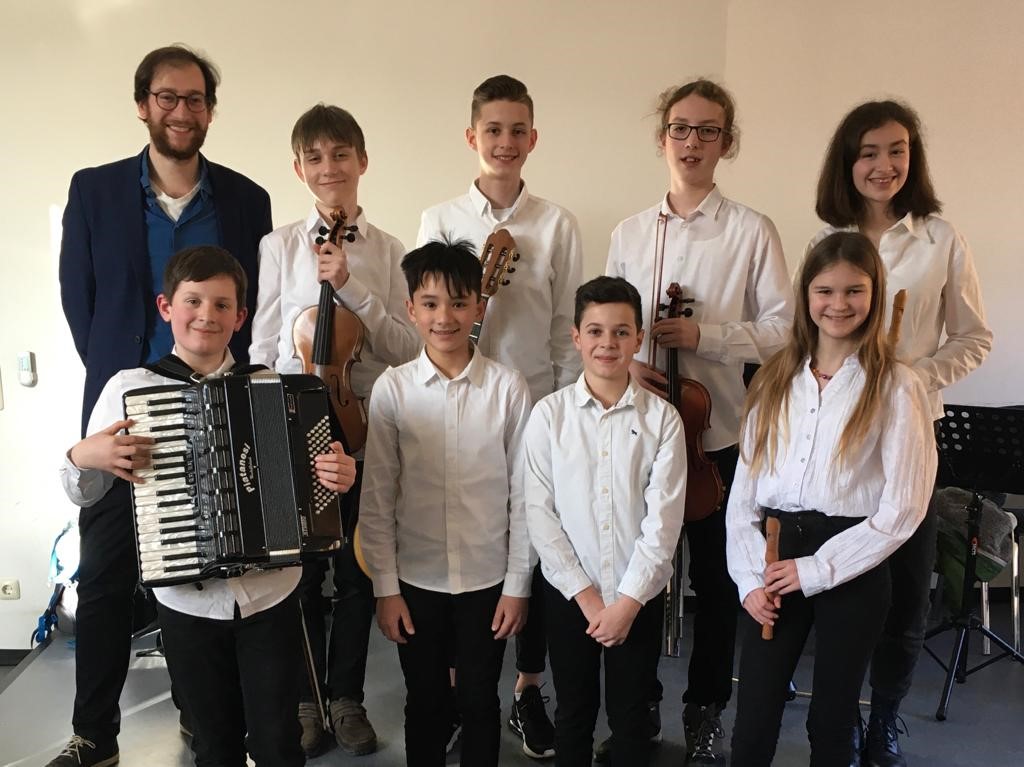 (von links) Michael Falter, die Schüler und Schülerinnen (Lukas Büttner/Bratsche, Joaquin Halicska/Violine, Jakob Durongphan/Schlagwerk, David Koberstein/Akkordeon, Elias Rapke/Gitarre, Paul Kalisch/Klavier, Mirja Lemke/Blockflöte, Vera Rahnhöfer/Blockflöte,), Aydin Pfeiffer und Johannes Lang.