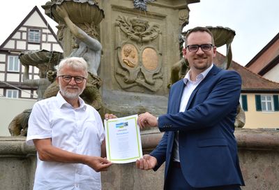 Oberbürgermeister Peter Reiß und Alt-Bürgermeister Roland Oeser freuen sich über die erneute Rezertifierung Schwabachs als Fairtrade-Town.