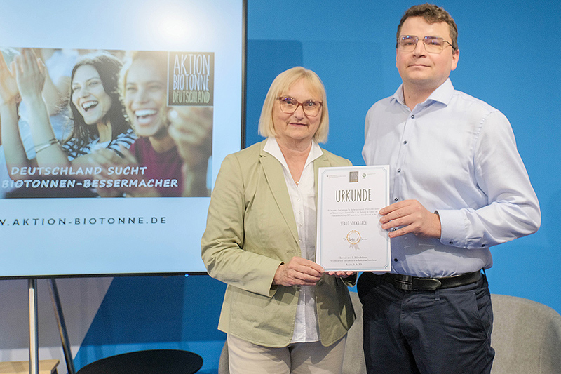 Abfallberater Lukas Arndt mit der Parlamentarischen Staatssekretärin Dr. Bettina Hoffmann bei der Urkundenübergabe