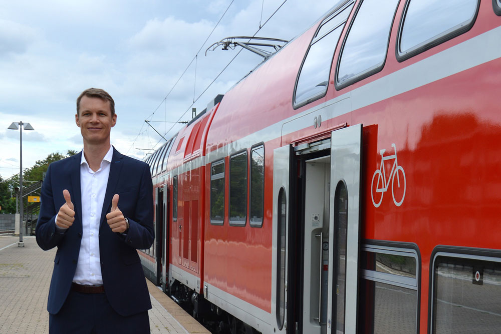 Oberbürgermeister Matthias Thürauf freut sich über das Votum. Oberbürgermeister Matthias Thürauf steht am Bahnsteig vor einem Regionalexpress.