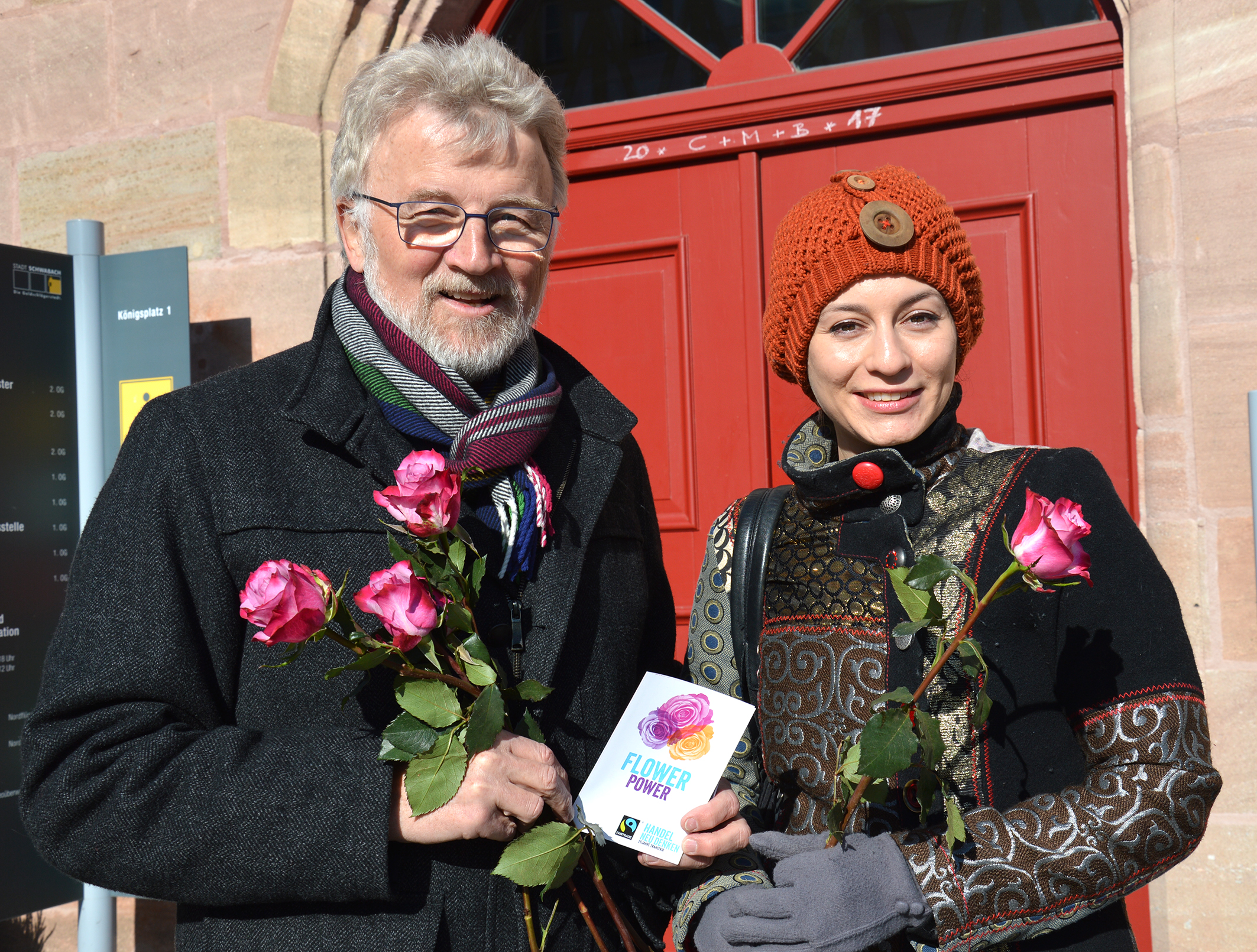 Dr. Roland Oeser übergibt eine Fairtrade-Rose an eine Schwabacherin.
