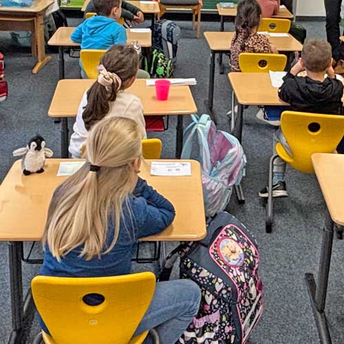 Kinder in einem Klassenraum, die man nur von hinten sieht
