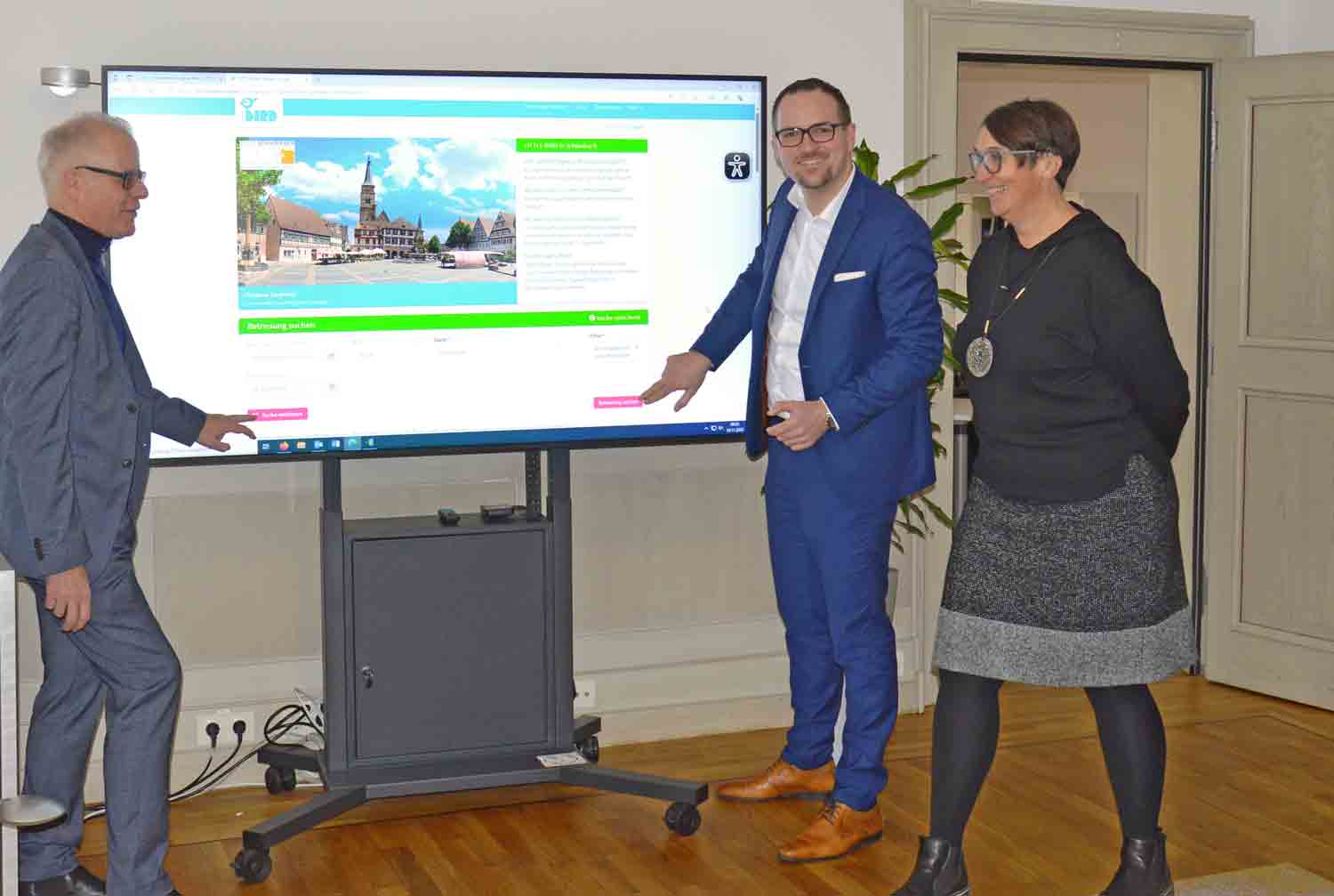 Oberbürgermeister, Referent und Jugendamtsleiterin schalten das Portal symbolisch frei, indem sie auf einem großen Bildschirm den Button drücken.