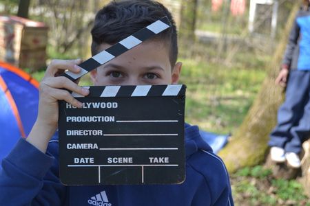Hier ist ein Kind während des Filmdrehs mit der Filmszenenklappe zu sehen