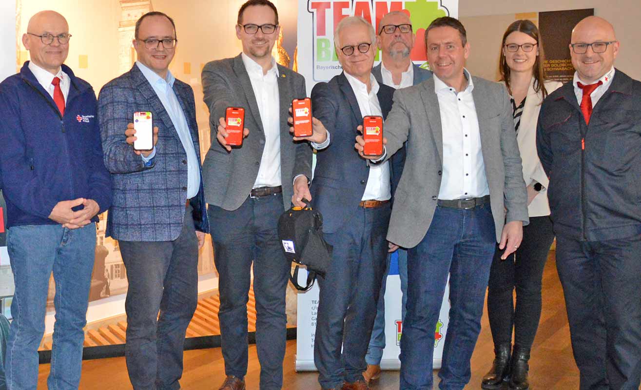 Die drei Schirmherren und der Vorsitzende des Zweckverbands halten Handys mit der App in die Kamera