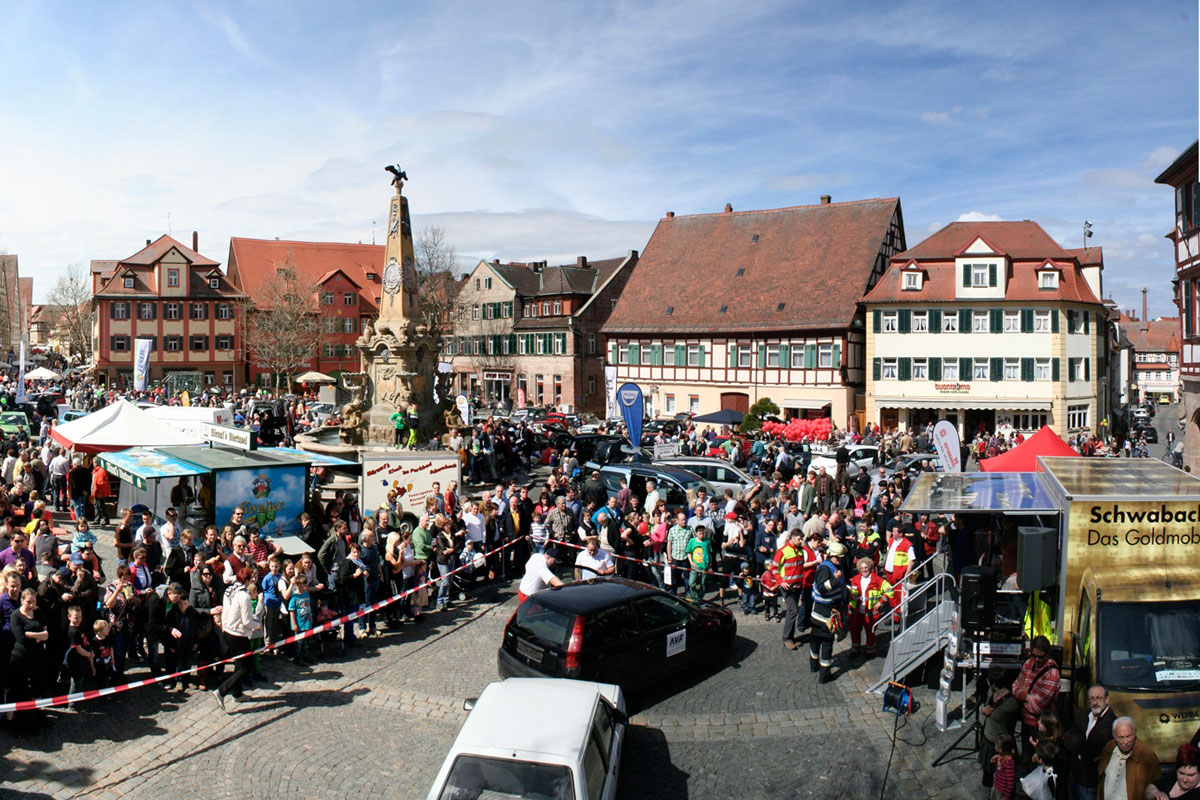 Auf dem Marktplatz bewundern zahlreiche Besucher die neuesten Fahrzeuge.
